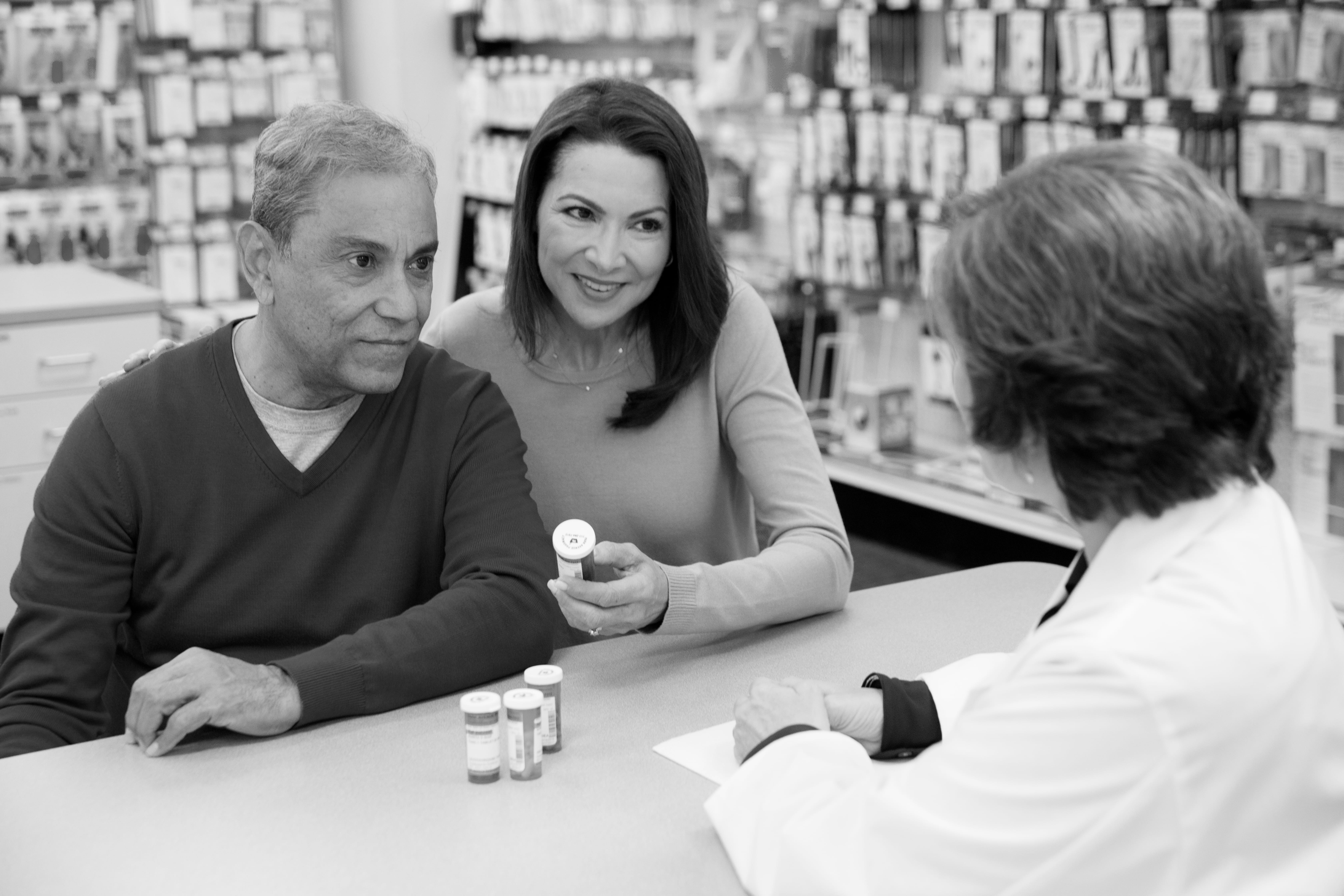 A pharmacist consults a patient and his caregiver