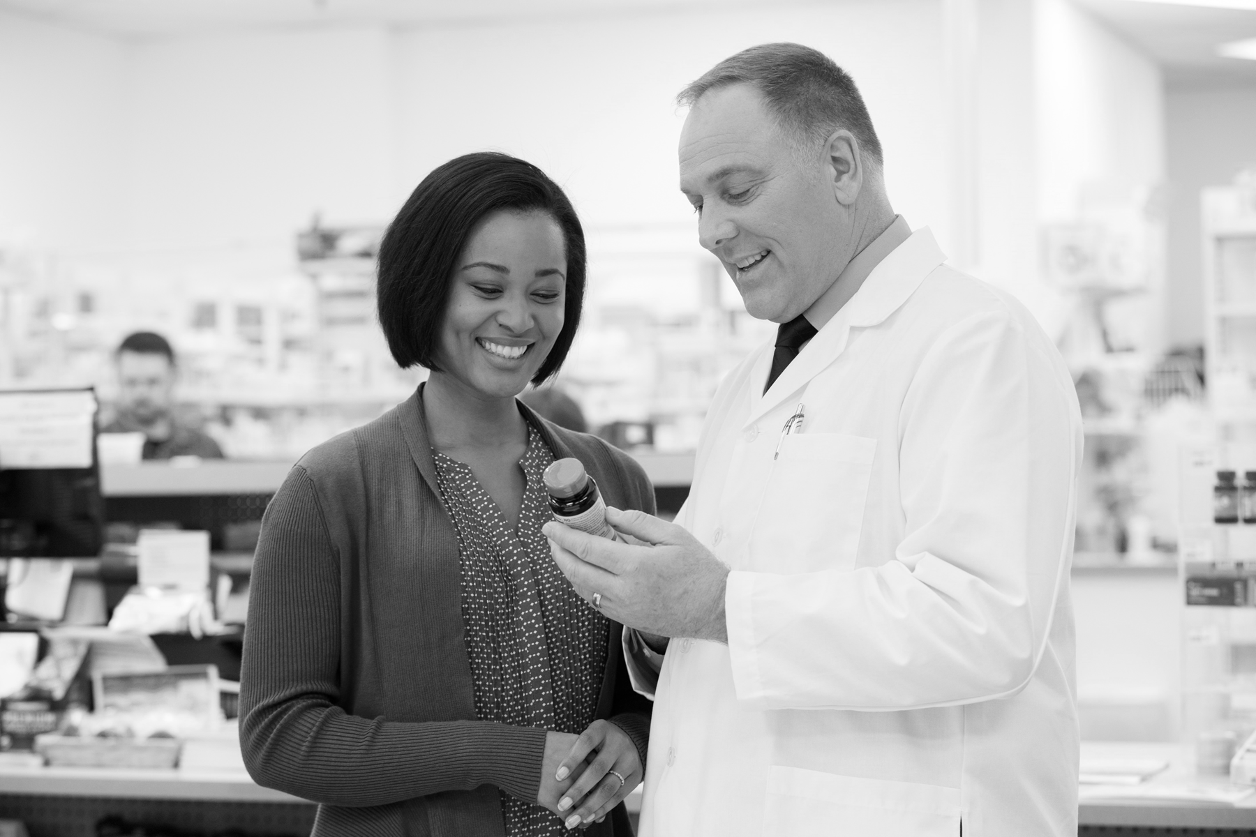 A pharmacist discussing the Good Neighbor Pharmacy free vitamin program with a patient