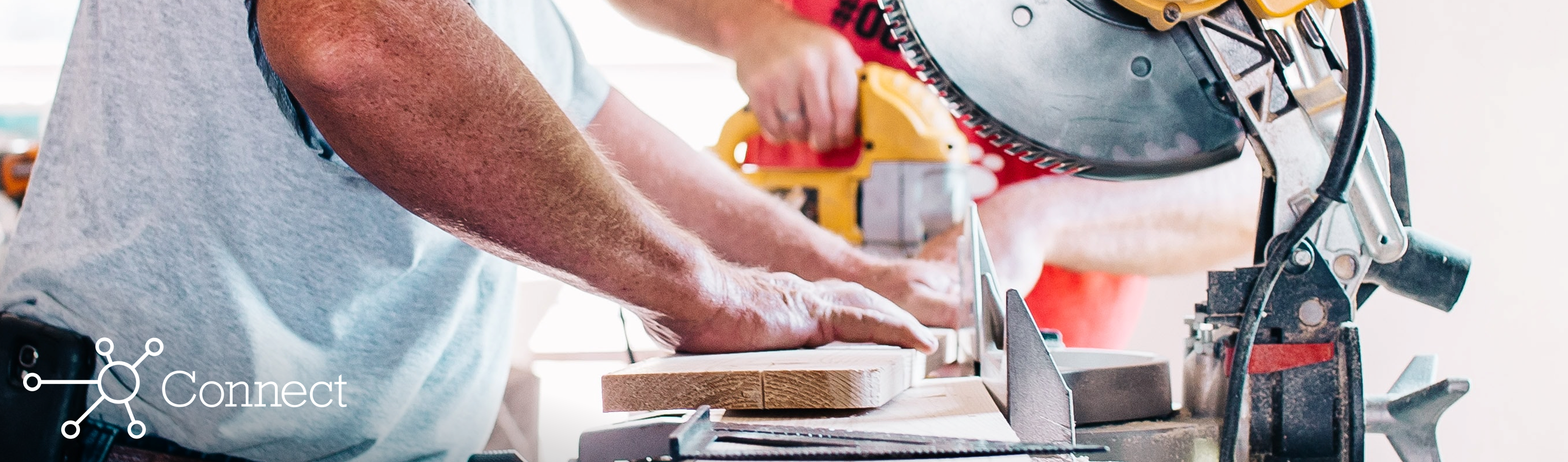 Two men sawing and drilling wood in a pharmacy under construction